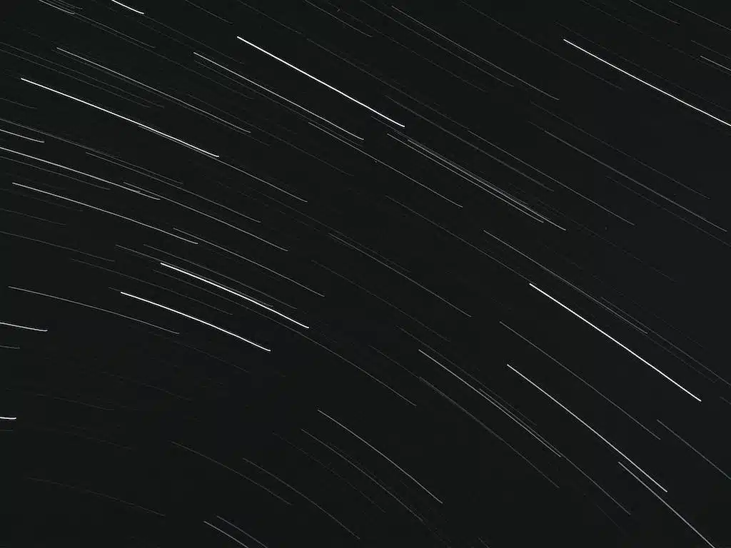 From below of bright glowing stars in long exposure on dark night sky